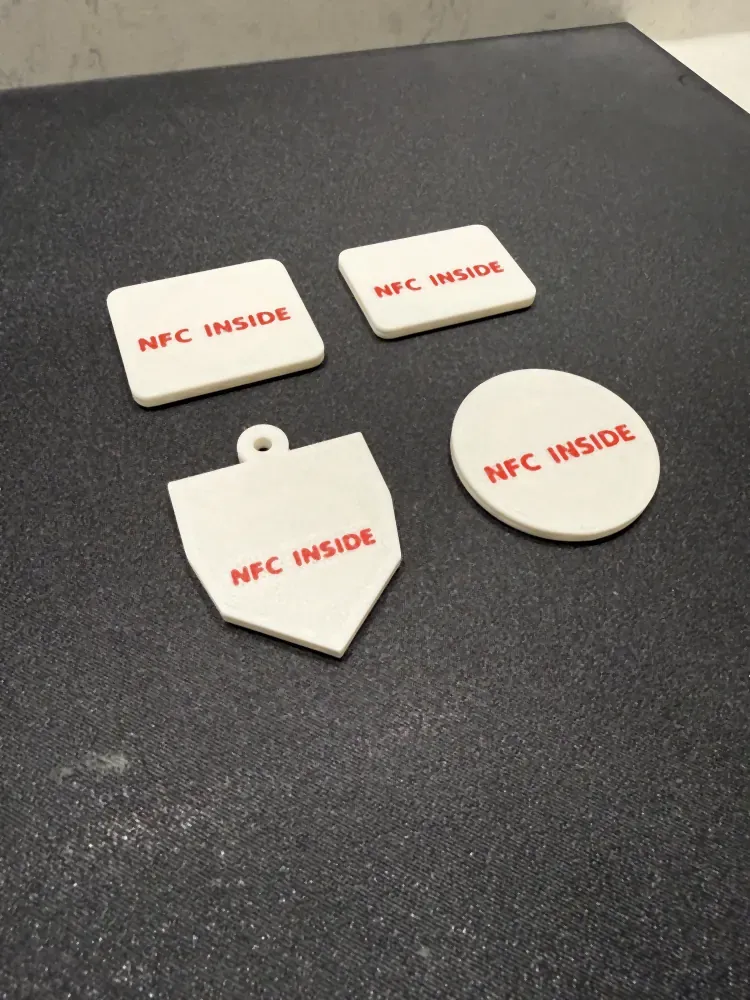 The backs of the same four NFC tags, each printed with a red NFC INSIDE mark